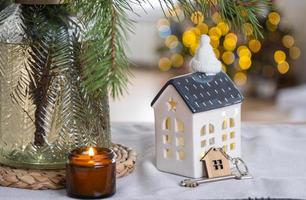 llave de la casa en un hogar acogedor con decoración navideña en la mesa de la cocina festiva. regalo para año nuevo. construcción, diseño, proyecto, mudanza a casa nueva, hipoteca, alquiler y compra de bienes inmuebles foto