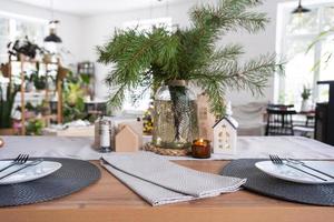 Festive Christmas decor in white kitchen, festive breakfast, white scandi interior. The figure of a cozy house ion the set table. New Year, mood, cozy home. Copy space photo