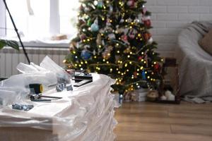Building materials with tools for home repair on the background of a Christmas tree - decorative repairs and construction for the new year photo