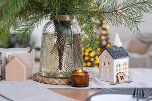 Key to the house on cozy home with Christmas decor on table of festive kitchen. Gift for New Year. Building, design, project, moving to new house, mortgage, rent and purchase real estate