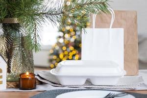 contenedores de servicio de entrega de alimentos en la mesa en la cocina blanca, servidos festivamente para la celebración de navidad y año nuevo. ahorro de tiempo, pedido en caliente, caja de plástico desechable, paquete artesanal. Bosquejo foto