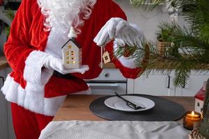 House key with keychain cottage in hands of Santa Claus outdoor in snow. Deal for real estate, purchase, construction, relocation, mortgage. Cozy home. Merry Christmas, new year booking event and hall photo