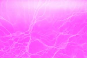 Defocus blurred transparent purple colored clear calm water surface texture with splashes and bubbles. Trendy abstract nature background. Water waves in sunlight with copy space. Pink water drop shine photo