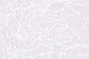 Defocus blurred transparent white colored clear calm water surface texture with splashes and bubbles. Trendy abstract nature background. Water waves in sunlight with copy space. Pink water drop shine photo