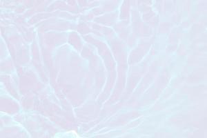 Defocus blurred transparent white colored clear calm water surface texture with splashes and bubbles. Trendy abstract nature background. Water waves in sunlight with copy space. Pink water drop shine photo
