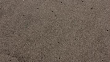 textura de arena de playa con agujero de gusano foto