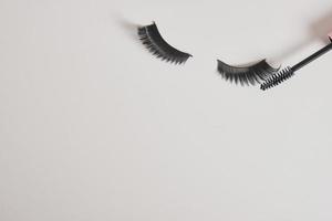 eyelashes makeup. Mascara and false eyelashes on gray background top view copy space photo