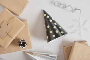 party hats and gifts boxes on gray background, shiny festive new year or christmas decor