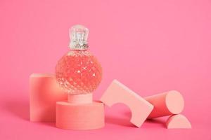 cristal glass perfume bottle on pink background copy space photo