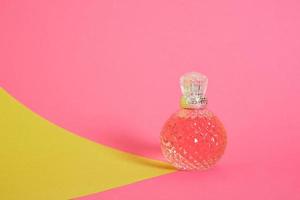 cristal glass perfume bottle on pink background photo