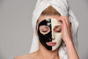 hermosa modelo femenina con máscara cosmética facial en blanco y negro foto