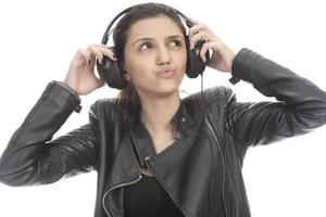 Beautiful modern girl singing favorite song, listening to music in wireless headphones, smiling and dancing photo
