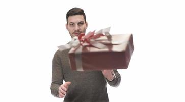 Young handsome man holding birthday present, looking positive and happy standing and smiling with a confident smile photo