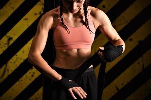 Close-up of a woman doing boxing bandages in a fighting cage photo