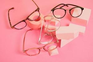 trendy eye glasses on geometric pink podiums, colorful background, copy space photo