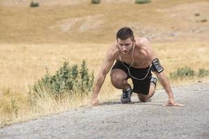 sporty man runner running on mountain plateau in summer photo