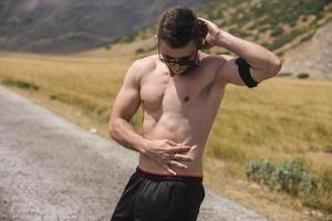 Athletic young man stretching after run in the nature. sport concept photo