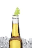 Mexican beer bottle with lime slice and frost on white background photo