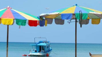 Visualizza attraverso il spiaggia ombrelli per il mare e il yacht. panorama blu mare e spiaggia. aereo al di sopra di il mare lungo tiro video