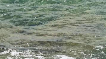 olhando através da água clara do oceano. padrões de areia e seixos são vistos através da água azul-turquesa do oceano. video