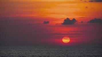 The big red sun sets over the ocean horizon. Rest and relaxation concept video