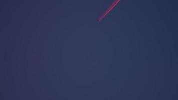 4k bela trilha de avião ao pôr do sol luz vermelha no céu azul, poluição da camada de aeronaves video