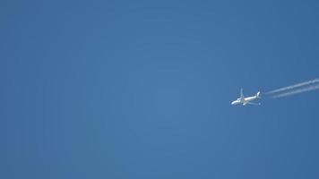 Airplane contrail in the blue sky. The plane flies overhead video