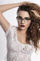 beautiful woman in white shirt and eye glasses posing in studio on white background photo