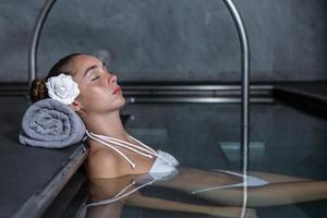 Young female chilling in spa pool photo