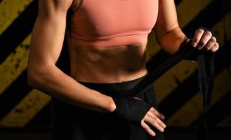 Close-up of a woman doing boxing bandages in a fighting cage photo