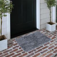 Designer Welcome Entry Doormat Placed on Solid Brick Floor Outside Entry Door with Plants photo