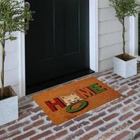 Designer Welcome Entry Doormat Placed on Solid Brick Floor Outside Entry Door with Plants photo