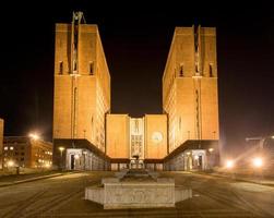 Oslo City Hall illuminated at night. It houses the city council, city administration, and art studios and galleries, 2022 photo