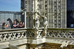Paris, France - May 17, 2017 -  Tourists taking photos of the gargoyles on the roof of the famous Notre Dame de Paris, Cathedral in France.