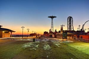 Coney Island Boardwalk with Parachute Jump in the background in Coney Island, NY. The boardwalk was built in 1923 and stretches for 2.51 miles photo