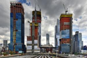 View of the Hudson Yards train depot and building development seen from the High Line, an elevated green urban park running along old rail track lines in New York City. photo