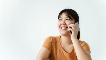 mujer asiática bastante joven que tiene una conversación telefónica con espacio de copia. foto