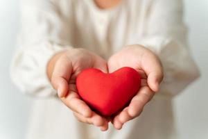 mujer sosteniendo un corazón rojo, amor, seguro médico, donación, feliz voluntario de caridad, día mundial de la salud mental, día mundial del corazón, día de san valentín foto