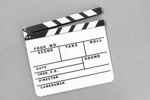 Top view of a White Movie clapper board on gray background. Template photo