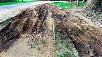 Cartire tracks on dark brown dirt road caused by rain water photo