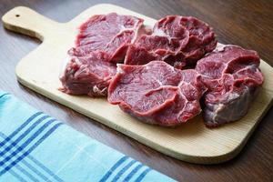 Fresh raw beef on wooden cutting plate photo