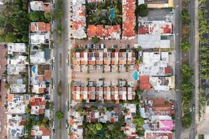 vista aérea de arriba hacia abajo de casas y complejos habitacionales en cancún, méxico. foto