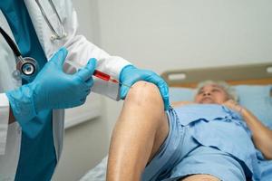 Asian doctor inject Hyaluronic acid platelet rich plasma into the knee of senior woman to walk without pain. photo