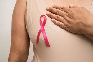 cáncer de mama, cinta rosa a la anciana asiática por apoyar la conciencia, símbolo del día mundial del cáncer de mama. foto