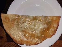 cheburek comida frita carne en masa en aceite en una sartén foto