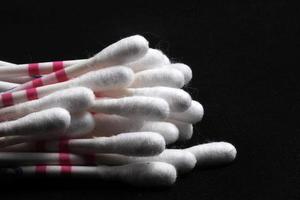 Collection of cotton buds to clean earwax isolated on black background photo