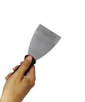 Hand holding a metallic putty knife on white background. A new putty knife with right hand in closeup photo