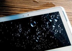 Drops of water on tablet screen photo