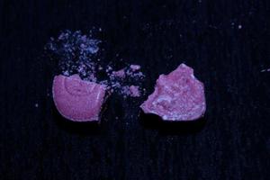 Pink skull ecstasy pill close up background high quality print purple army dope narcotics substance high dose psychedelic way of life photo