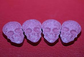 rosa cráneo éxtasis píldora primer plano fondo alta calidad impresión púrpura ejército droga narcóticos sustancia alta dosis psicodélico forma de vida foto